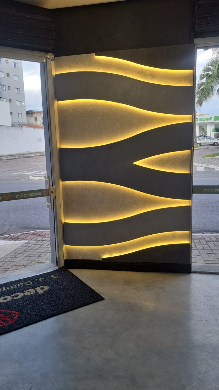 Fachada com parede texturizada e LED dourado